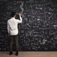 انسان معادلات ریاضی را روی تخته سیاه می نویسد