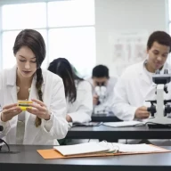دانش آموزان با میکروسکوپ در آزمایشگاه علوم.