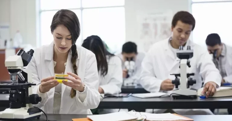 دانش آموزان با میکروسکوپ در آزمایشگاه علوم.