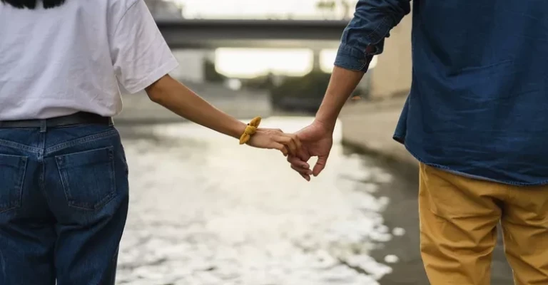 فرانسه، پاریس، زوجی که دست در دست هم در کنار رودخانه سن هستند