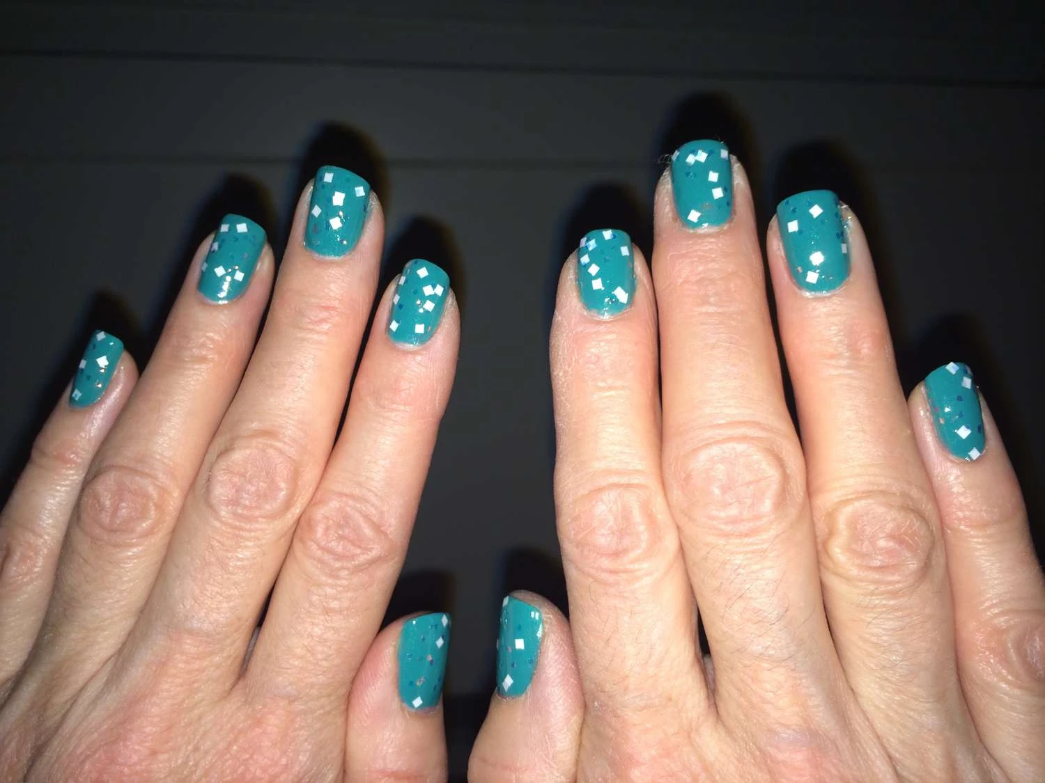 استفاده از اکلیل یا اشکال درخشان روی لاک ناخن برای ایجاد اثر شب&zwnj;تاب