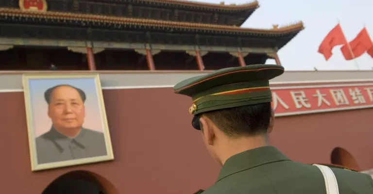 چین، پکن. سربازی در مقابل پرتره مائو تسه‌تونگ در ورودی اصلی شهر ممنوعه در پکن ایستاده است.