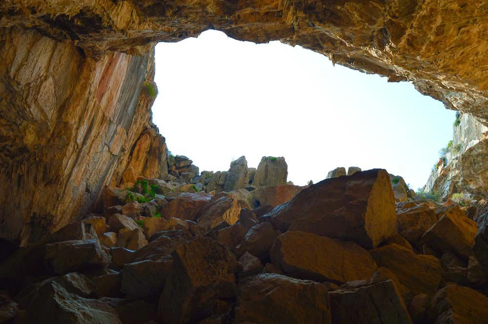 ایستادن در داخل غار فرانختی در یونان و نگاه به سمت دهانه غار