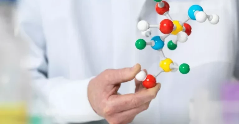 دانشمندی که مدلی از یک ترکیب را در دست دارد