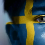 پسری با پرچم سوئد که روی صورتش نقاشی شده است