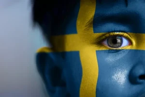 پسری با پرچم سوئد که روی صورتش نقاشی شده است