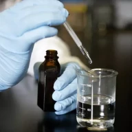 مردی به یک لیوان آب اسید اضافه می‌کند