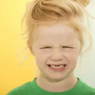 دختر بچه‌ای با دندان‌های افتاده